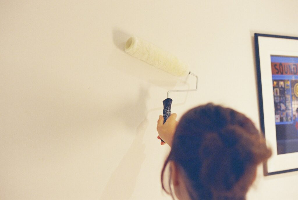 Persona pintando la pared de un piso en reforma